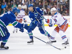 Vancouver Canucks forward Jannik Hansen, centre, battles New York Rangers’ Oscar Lindberg, right. ‘Special teams are so important in this league and you see what they can do when they are going for you,’ Hansen said of the Canucks’ perfect penalty-kill record in Wednesday’s win.