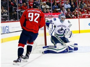 Vancouver Canucks goalie Ryan Miller (30) blocks a shot as Washington Capitals center Evgeny Kuznetsov (92), from Russia, waits for the rebound, in the first period of an NHL hockey game, Thursday, Jan. 14, 2016, in Washington.