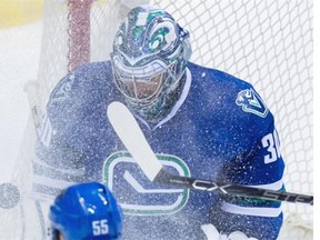 Vancouver Canucks’ goalie Ryan Miller is showered with snow as he makes a save against the Nashville Predators during second period NHL hockey action, in Vancouver on Tuesday, Jan. 26, 2016.
