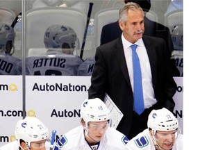 Vancouver Canucks head coach Willie Desjardins looks on against the Colorado Avalanche in the first period of an NHL hockey game Tuesday, Feb. 9, 2016 in Denver.