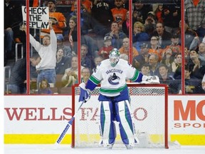 Vancouver Canucks’ Jacob Markstrom clears ice in front of the net after giving up a booth-reviewed goal to Philadelphia Flyers’ Michael Raffl during the first period of an NHL hockey game, Thursday, Dec. 17, 2015, in Philadelphia.