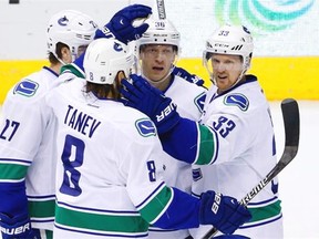 Vancouver Canucks’ Jannik Hansen (36), of Denmark, celebrates his goal against the Arizona Coyotes with Ben Hutton (27), Chris Tanev (8), and Henrik Sedin (33), of Sweden, during the second period of an NHL hockey game Wednesday, Feb. 10, 2016, in Glendale, Ariz.