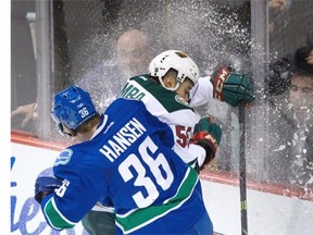 Vancouver Canucks’ Jannik Hansen (36), of Denmark, checks Minnesota Wild’s Matt Dumba.