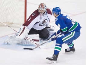 Vancouver Canucks’ Jannik Hansen, right, of Denmark, scores against Colorado Avalanche goalie Semyon Varlamov, of Russia, during the third period of an NHL hockey game in Vancouver, B.C., on Sunday February 21, 2016.