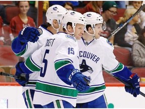 Vancouver Canucks’ Jared McCann, right, celebrates his goal against the Arizona Coyotes with Derek Dorsett (15) and Adam Cracknell, left, during the first period of an NHL hockey game Friday, Oct. 30, 2015, in Glendale, Ariz.