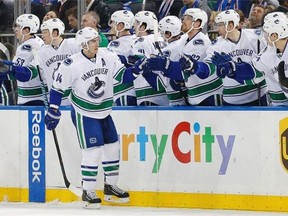 Vancouver Canucks left wing Alex Burrows (14) is greeted by teammates after scoring a goal against the New York Rangers during the second period of an NHL hockey game Tuesday, Jan. 19, 2016, in New York.