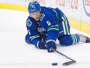 Vancouver Canucks’ Luca Sbisa, of Italy, reaches for the puck after falling to the ice during the first period of an NHL hockey game against the Washington Capitals in Vancouver, B.C., on Thursday October 22, 2015.