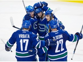 Vancouver Canucks’ Radim Vrbata, of the Czech Republic, from left, Henrik Sedin, of Sweden, Alexander Edler, of Sweden, Alex Burrows and Daniel Sedin, of Sweden, celebrate Edler’s goal against the New York Rangers during third period NHL hockey action, in Vancouver, on Wednesday, Dec. 9, 2015.