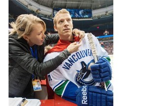 Vancouver Canucks’ staff member Karen Christiansen puts a cape on Jannik Hansen during the NHL team’s skills competition last December at Rogers Arena. The Danish high school grad has been super at times during his 500 NHL appearances.