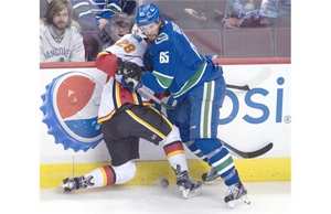 Vancouver Canucks winger Alexandre Grenier (65) fights for control of the puck with Calgary Flames left wing Emile Poirier (28) during first period pre-season NHL action Vancouver, B.C. Saturday, Sept. 26, 2015. The Vancouver Canucks have recalled right-wing Grenier from the Utica Comets of the American Hockey League.