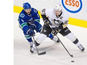 Vancouver Canucks #6 Yannick Weber ( L ) shadows Pittsburgh Penguins #87 Sidney Crosby ( R ) in the first period of a regular season NHL hockey game at Rogers Arena Vancouver, February 07 2015.