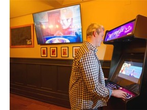VANCOUVER February 05 2016.  Sean Cranbury places a custom built arcade game that plays retro games at the new Storm Crow Alehouse, 1619 West Broadway, Vancouver, February 05 2016.  Gerry Kahrmann  /  PNG staff photo) / PNG staff photo) ( For Sun Lifestyle ) 00041591A