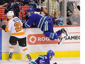 Vancouver Canucks defenceman Yannick Weber goes airborne against Philadelphia Flyers winger Claude Giroux during the Flyers' last visit to Rogers Arena last March.