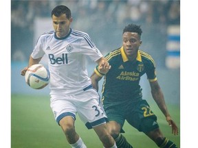 Vancouver Whitecaps Steven Beitashour, left battles for the ball with Portland Timbers Rodney Wallace, right during the second leg of the MLS Western Conference semifinal match at B.C. Place Stadium in Vancouver, B.C. Sunday November 8, 2015.