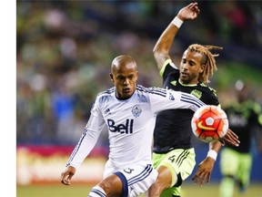 Vancouver Whitecaps forward Robert Earnshaw (left) and Seattle Sounders defender Tyrone Mears watch as a long pass bounces away from them during the second half of a CONCACAF Champions League soccer match on Wednesday, Sept. 23, 2015, in Seattle. Earnshaw announced his retirement as a player on Thursday.
