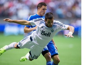 Vancouver Whitecaps striker Octavio Rivero gets knocked off stride by the Montreal Impact’s Donny Toia during a game between the two teams last season at BC Place Stadium. The clubs will open the 2015 MLS season on March 6, also at BC Place.