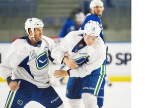 Veteran Brandon Prust (left) play fights with rookie Jake Virtanen, showing him how to handle himself during a Vancouver Canucks practice prior to the start of the regular season. Now Prust is on the receiving end of roster decisions that see Virtanen replacing him in the lineup.