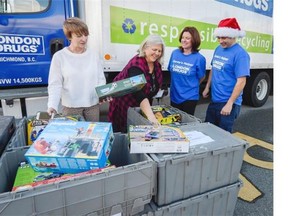 Vice principal Erin Gibbs, left and principal Margaret Jorgensen, centre left accepts a pallet load of toys from London Drug employees Wendy Hartley, centre right and Kevin Wilson, right at John Norquay Elementary School in Vancouver.