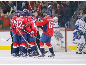 Washington Capitals defenseman Karl Alzner (27) celebrates with teammates after his goal past Vancouver Canucks goalie Ryan Miller, right, in the second period of an NHL hockey game, Thursday, Jan. 14, 2016, in Washington.