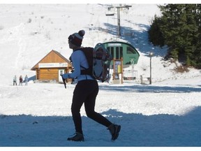 A woman carries her snowshoes on Thursday at Cypress Mountain in North Vancouver, which opens for downhill skiing this weekend.