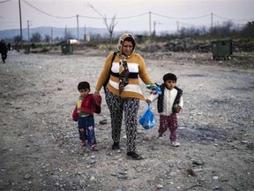 A woman and her children walk to a registration camp after crossing the Greek-Macedonian border on Tuesday. More than 800,000 refugees and migrants have landed in Europe so far this year and more than 3,000 have died while crossing the Mediterranean in search of a new life.
