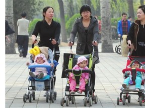 Women push babies in prams through a Beijing park during a public holiday. China announced the end of its hugely controversial one-child policy on Thursday.
