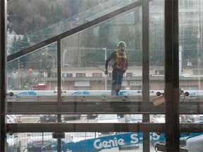 Workers install glass at the Moody Centre station on th Evergreen Line.