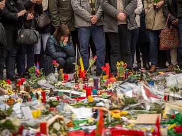 A woman reacts during a minute of silence held at a makeshift memorial in front of Brussel's Stock Exchange on Place de la Bourse (Beursplein) on March 24, 2016, two days after a triple bomb attack, claimed by the Islamic State group, hit Brussels' airport and the Maelbeek - Maalbeek metro station, killing 31 people and wounding 300 others.    Belgian authorities are seeking a second suspect over the attack on a metro train in Brussels in which one suicide bomber has already been confirmed dead, police sources told AFP on March 24. PHILIPPE HUGUEN/AFP/Getty Images