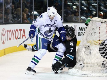 Henrik Sedin #33 of the Vancouver Canucks checks Paul Martin #7 of the San Jose Sharks as they go for the puck at SAP Center on March 31, 2016 in San Jose, California.  (Photo by Ezra Shaw/Getty Images)