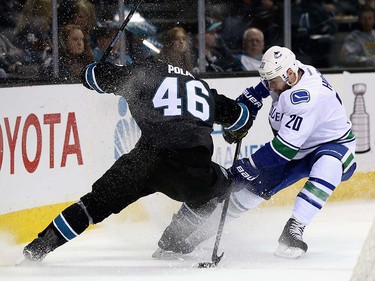 Chris Higgins #20 of the Vancouver Canucks and Roman Polak #46 of the San Jose Sharks go for the puck at SAP Center on March 31, 2016 in San Jose, California.  (Photo by Ezra Shaw/Getty Images)