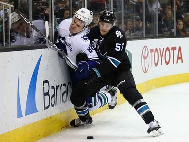 Tommy Wingels #57 of the San Jose Sharks checks Nikita Tryamkin #88 of the Vancouver Canucks at SAP Center on March 31, 2016 in San Jose, California.  (Photo by Ezra Shaw/Getty Images)