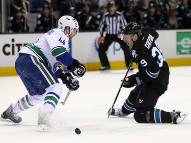 Logan Couture #39 of the San Jose Sharks and Matt Bartkowski #44 of the Vancouver Canucks go for the puck at SAP Center on March 31, 2016 in San Jose, California.  (Photo by Ezra Shaw/Getty Images)
