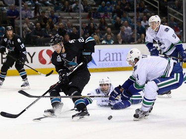 Dan Hamhuis #2 and Nikita Tryamkin #88 of the Vancouver Canucks steal the puck from Joonas Donskoi #27 of the San Jose Sharks at SAP Center on March 31, 2016 in San Jose, California.  (Photo by Ezra Shaw/Getty Images)