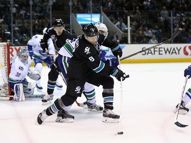 Joe Pavelski #8 of the San Jose Sharks tries to control the puck during their game against the Vancouver Canucks at SAP Center on March 31, 2016 in San Jose, California.  (Photo by Ezra Shaw/Getty Images)