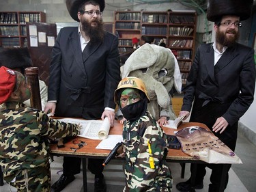 Ultra-Orthodox Jewish men and dressed up children read the book of Esther at a synagogue in the Israeli city of Beit Shemesh on March 23, 2016 during the feast of Purim.  The carnival-like Purim holiday is celebrated with parades and costume parties to commemorate the deliverance of the Jewish people from a plot to exterminate them in the ancient Persian empire 2,500 years ago, as recorded in the Biblical Book of Esther. MENAHEM KAHANA/AFP/Getty Images