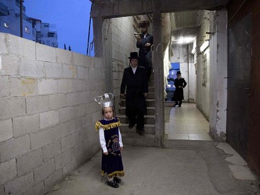 A dressed up ultra-Orthodox child looks at the photographer before reading the book of Esther at a synagogue in the Israeli city of Beit Shemesh on March 23, 2016 during the feast of Purim.  The carnival-like Purim holiday is celebrated with parades and costume parties to commemorate the deliverance of the Jewish people from a plot to exterminate them in the ancient Persian empire 2,500 years ago, as recorded in the Biblical Book of Esther. MENAHEM KAHANA/AFP/Getty Images