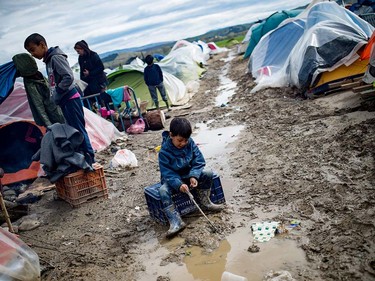 A boy plays in a puddle at a makeshift camp occupied by migrants and refugees at the Greek-Macedonian border near the village of Idomeni on March 24, 2016.  The UN refugee agency harshly criticized an EU-Turkey deal on curbing the influx of migrants to Greece, saying reception centers had become "detention facilities", and suspended some activities in the country. The EU and Ankara struck a deal on Friday aiming to cut off the sea crossing from Turkey to the Greek islands that enabled 850,000 people to pour into Europe last year, many of them fleeing the brutal war in Syria. ANDREJ ISAKOVIC/AFP/Getty Images