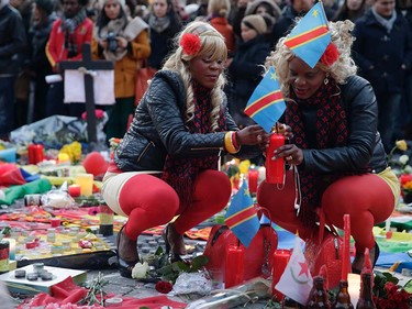 Women lights candles as people gather at a makeshift memorial on the Place de la Bourse (Beursplein) in Brussels on March 23, 2016, a day after a triple bomb attack, which responsibility was claimed by the Islamic State group, left 31 dead and hundreds injured in the Belgian capital. World leaders united in condemning the carnage in Brussels and vowed to combat terrorism, after Islamic State group bombers killed 31 people in a strike at the symbolic heart of the EU. KENZO TRIBOUILLARD/AFP/Getty Images
