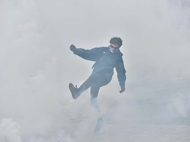 A French student kicks a tear gas canister fired by riot police after clashes erupted in the western city of Nantes during a protest against proposed labour reforms on March 24, 2016. Security forces responded with tear gas as French students protesting proposed labour reforms hurled bottles at riot police in Paris and the western city of Nantes. LOIC VENANCE/AFP/Getty Images