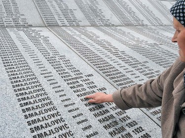 Bida Smajlovic, 64, survivor of July 1995 massacre in Srebrenica, stands at a memorial center in Potocari, on March 24, 2016, while pointing at the name of her husband, engraved among names of other victims of the massacre.  UN war crimes judges on March 24, 2016 found former Bosnian Serb leader Radovan Karadzic guilty of genocide and sentenced him to 40 years in jail over the worst atrocities in Europe since World War II.  ELVIS BARUKCIC/AFP/Getty Images