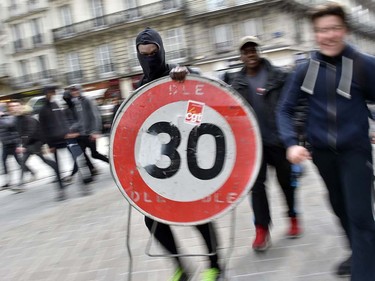 A protester holds a speed limit sign  on March 24, 2016 in Nantes, western France, during a demonstration against the French government's proposed labour reforms. Students protesting labour reforms took to the streets across France on March 24, torching cars in Paris and clashing with riot police who responded with tear gas and made about two dozen arrests. Fifteen protesters were arrested in Paris, where two policemen were injured, and another nine students were detained in the western city of Nantes. LOIC VENANCE/AFP/Getty Images