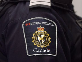 A Canadian Border Services agent stands watch at Pearson International Airport in Toronto, Ont. on Tuesday, December 8, 2015.