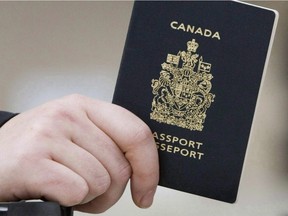 A passenger holds his Canadian passport before boarding a flight in Ottawa on Jan 23, 2007.