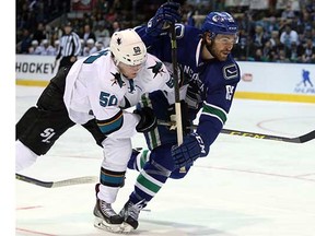 Alex Grenier of the Vancouver Canucks (right) battles with San Jose Shark Chris Tierney during an NHL pre-season game in Victoria last September. (Bruce Stotesbury, Times Colonist)