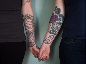Tattoo artist Auberon Wolf, left, and client Jenny Magenta display tattoos on their forearms while standing for a photograph in Vancouver, B.C., on Tuesday March 22, 2016. People who have attempted suicide and been the victims of physical assault are finding a psychological healing by having their scars incorporated into tattoos. During busy weeks, Vancouver tattoo artist Auberon Wolf will collaborate with upwards of 10 clients on their designs.