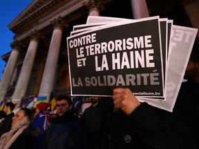 A person holds a placard reading "Against terrorism and hatred - Solidarity" during a gathering to pay tribute to the victims of the Brussels attacks on the Place de la Bourse (Beursplein) in central Brussels, on March 25, 2016, three days after a triple bomb attack, which responsibility was claimed by the Islamic State group, hit Brussels' airport and the Maelbeek - Maalbeek subway station, killing 31 people and wounding 300 others.