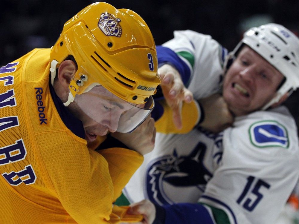 Los Angeles Kings defenseman Brayden McNabb, left, fights against Vancouver Canucks right wing Derek Dorsett (15) during the third period of an NHL hockey game in Los Angeles, Monday, March 7, 2016. The Kings won 5-1.