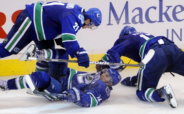 Canucks players mob Alex Burrows after he scored the game winning goal  against the Chicago Blackhawks in  game 7 of the playoffs in Vancouver's Rogers Arena on April 26, 2011.   (Mark van Manen/ PNG)   