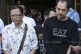 Khamla Wong, a Laos-born Canadian drug suspect, right and his Chinese accomplice, Fangyong Saeyang, are escorted by police from a condominium on Rama IX Road Bangkok