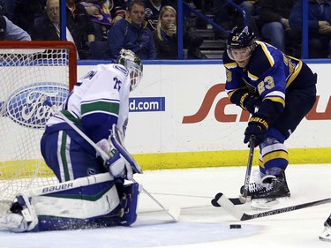 St. Louis Blues' Dmitrij Jaskin, of Russia, reaches for a loose puck as Vancouver Canucks goalie Jacob Markstrom defends during the second period of an NHL hockey game Friday, March 25, 2016, in St. Louis. (AP Photo/Jeff Roberson)